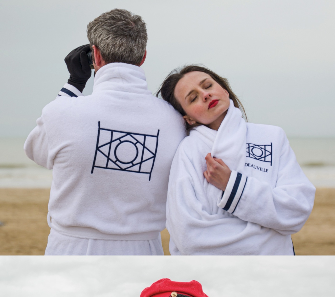 Couple en peignoirs blancs brodés face à la mer